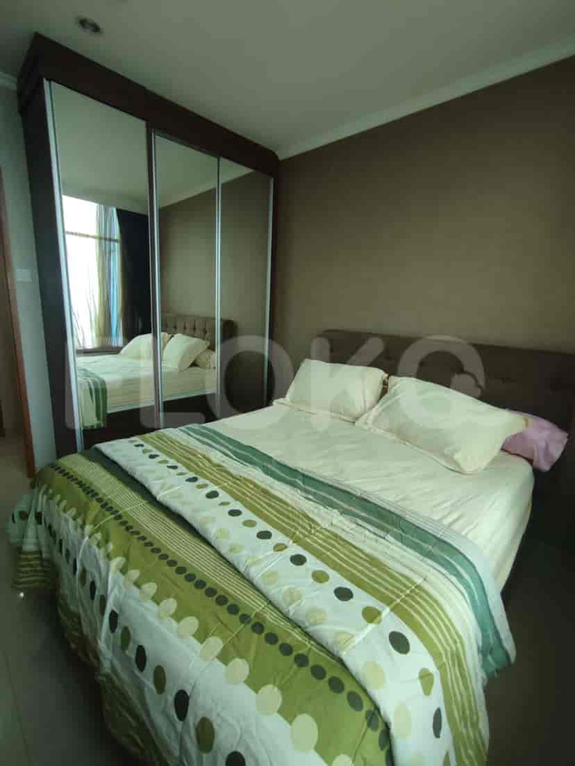 Kamar tidur dengan tempat tidur, lemari pakaian, dan jendela besar.