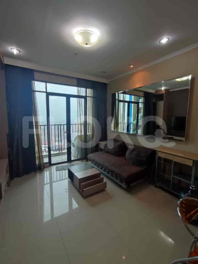 Ruang tamu yang menampilkan sofa, meja kopi, dan jendela besar dengan balkon.