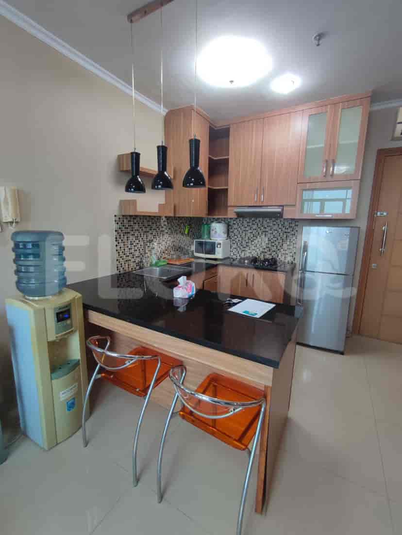 Dapur modern yang menampilkan meja sarapan dan kombinasi lemari kayu dan peralatan stainless steel.