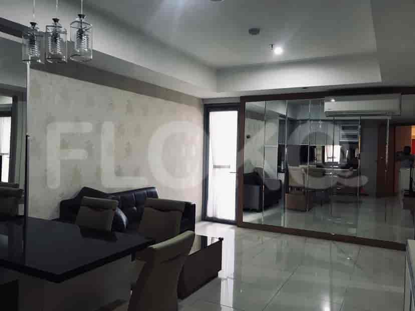 Ruang tamu modern yang menampilkan sofa abu-abu tua, meja makan, dan cermin dekoratif.