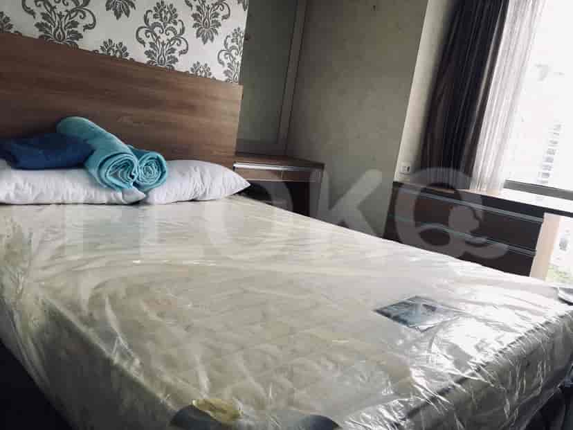 Kamar tidur yang nyaman yang menampilkan tempat tidur dengan bantal dan handuk, bersama dengan sandaran kepala kayu.