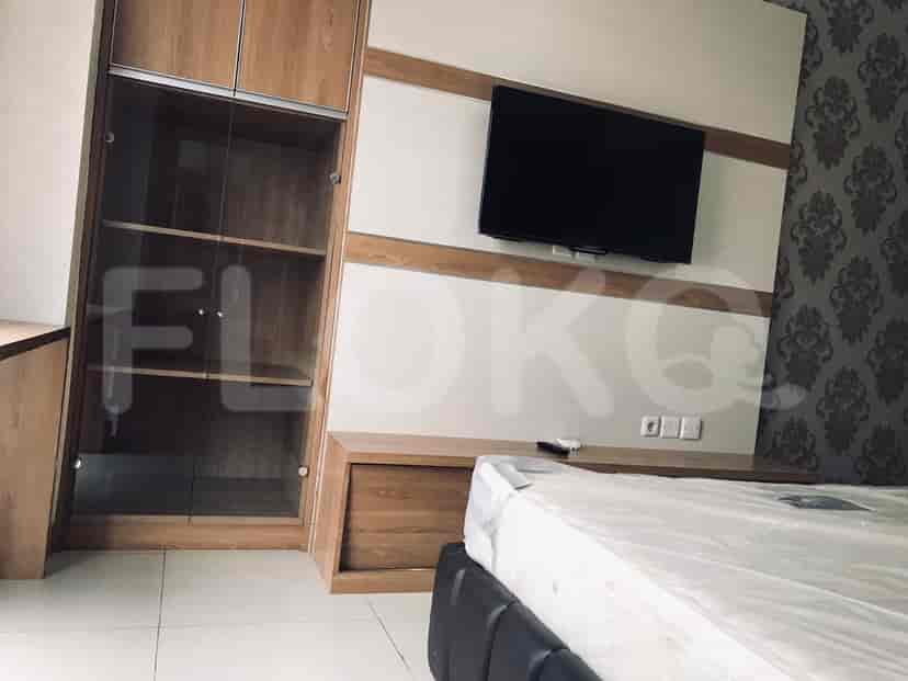 Kamar tidur dengan TV dan penyimpanan, bersama dengan tempat tidur yang ditutupi plastik.
