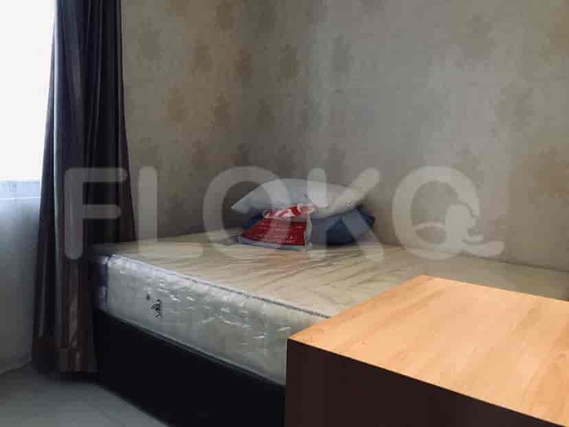 Kamar tidur ringkas dengan tempat tidur tunggal dan meja samping tempat tidur.