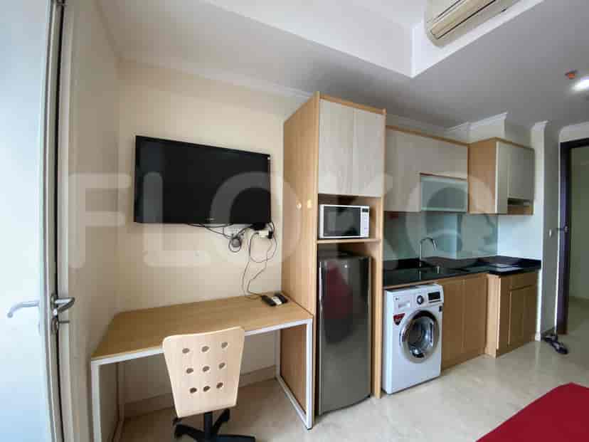 Combined kitchen and bedroom with a desk, a bed, and kitchen appliances.