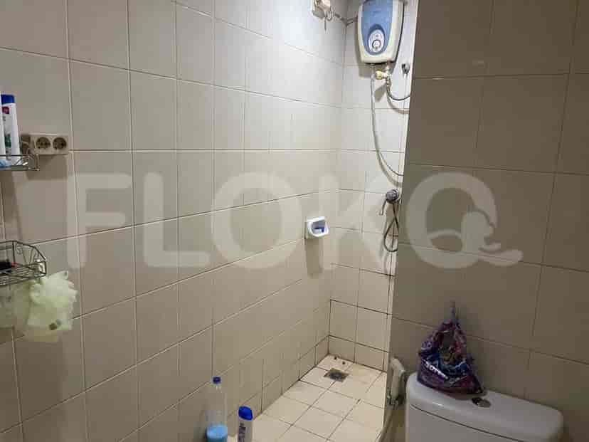 Kamar mandi kecil dengan ubin, toilet, dan shower.