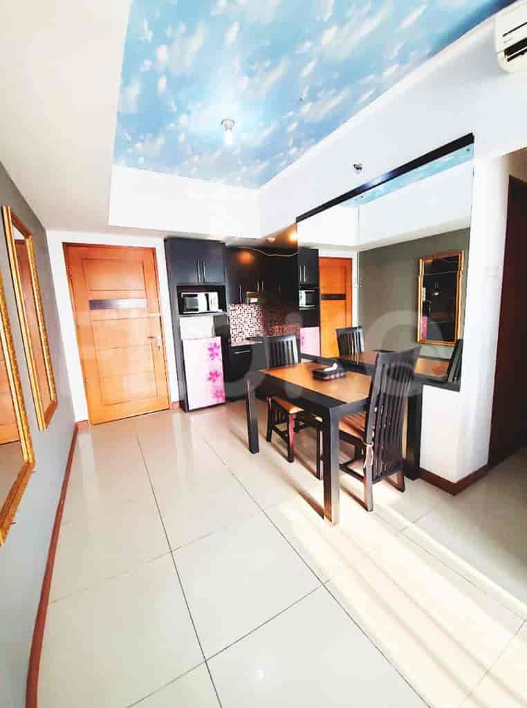 Dining area with wooden dining table and chairs, and an adjacent kitchen with appliances.