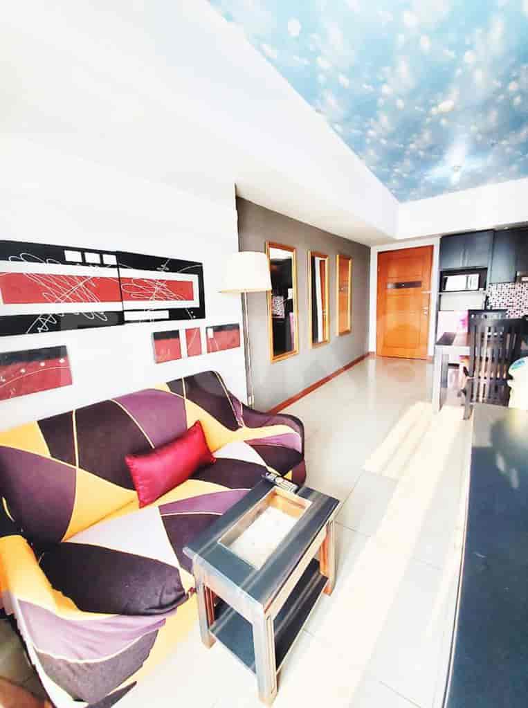 Living room with a patterned sofa, coffee table, and abstract artwork, featuring a painted sky ceiling.