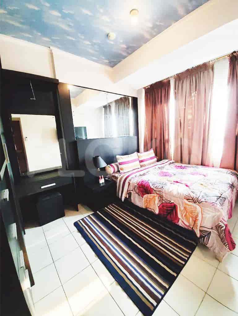 Bedroom with a bed, mirror, and decorative rug.