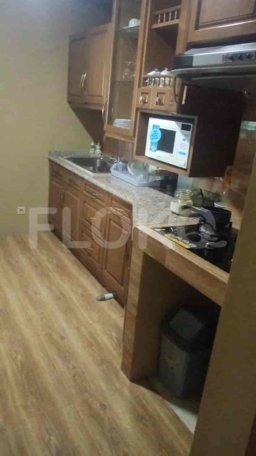 A kitchen with wooden cabinets, granite countertops, and a microwave.