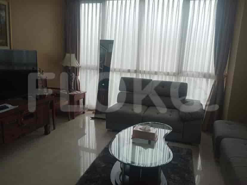 A living room with a sofa, table, and large window.