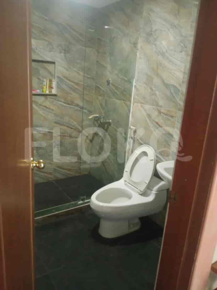 A bathroom with a toilet, shower, and vanity.