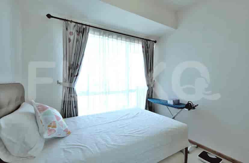 Simple bedroom with a bed and a small ironing board.