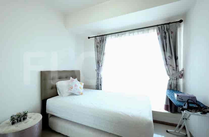 Kamar tidur yang menampilkan tempat tidur tunggal, jendela, dan meja.