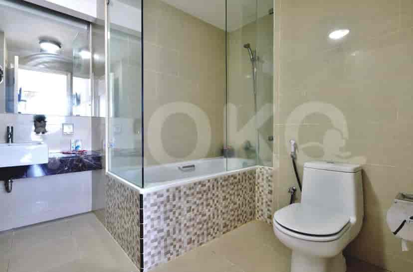Kamar mandi modern yang menampilkan bak mandi, pancuran, dan toilet.