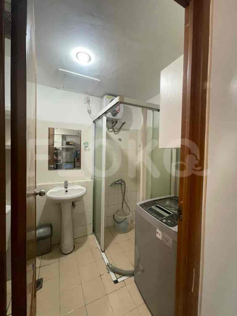 The bathroom with shower and washing machine.