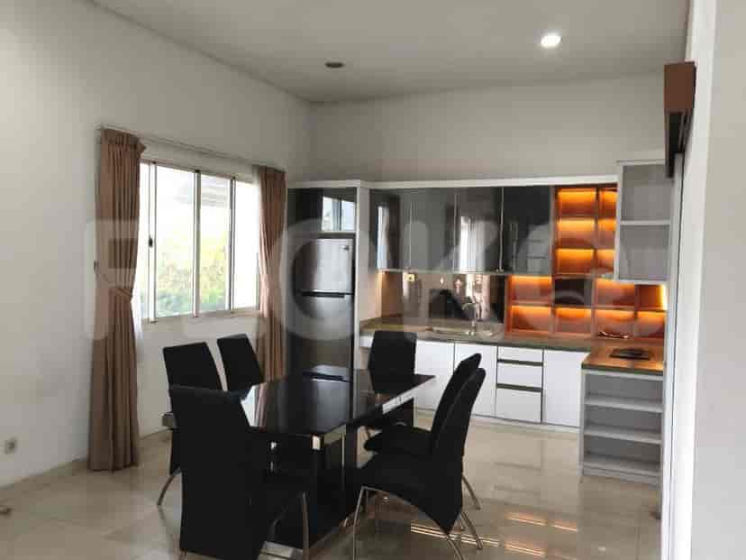 A dining area with a black table and chairs adjacent to a kitchen with modern appliances.