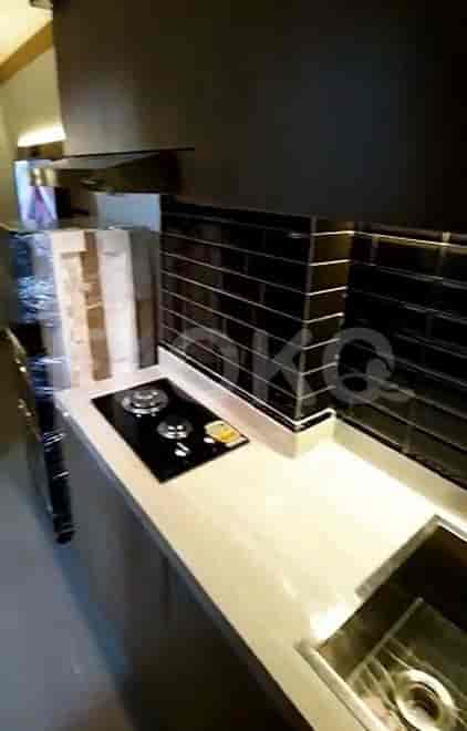 A modern kitchen setup with a gas stove and black tiled backsplash.