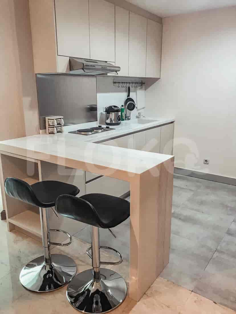 A modern kitchen with a breakfast bar, electric stove and overhead cabinets.