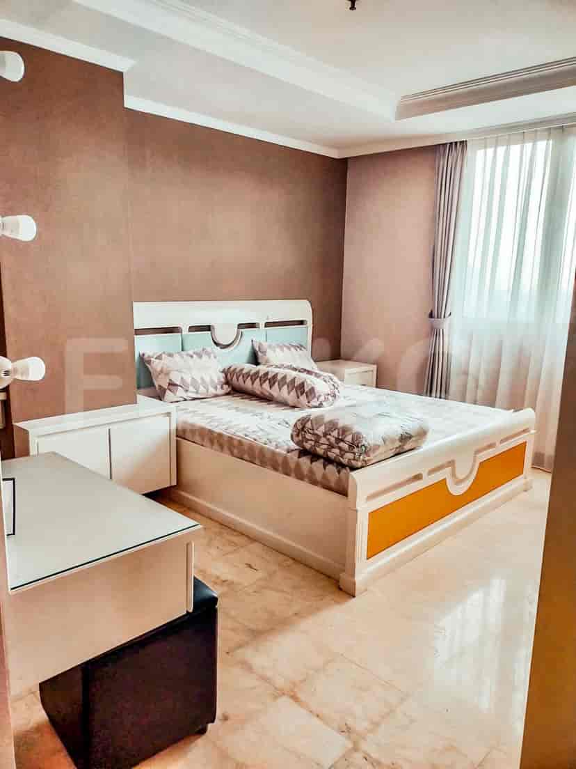 A bedroom with a double bed, bedside tables, and a brown accent wall.