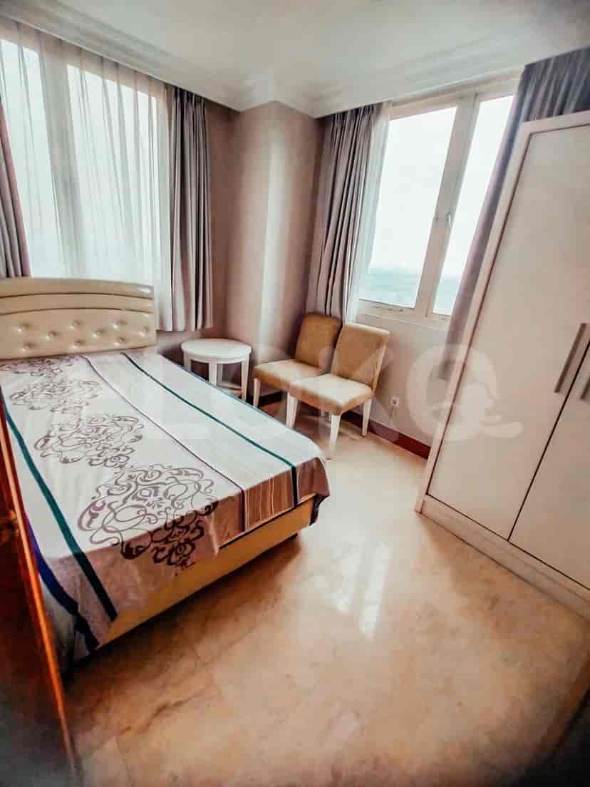 A bedroom with a single bed and large windows.