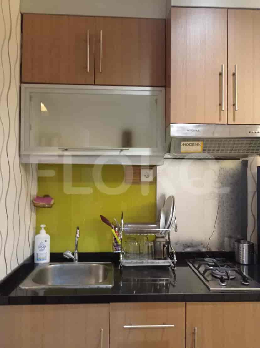 A kitchen with cabinets, a sink, a stove, and a glass backsplash.