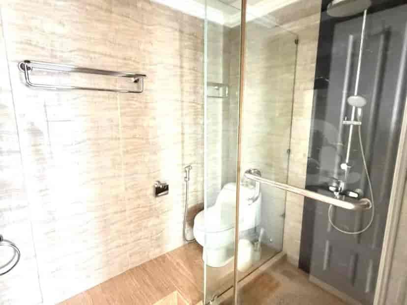 A modern bathroom with a glass-enclosed shower, toilet, and tiled walls.