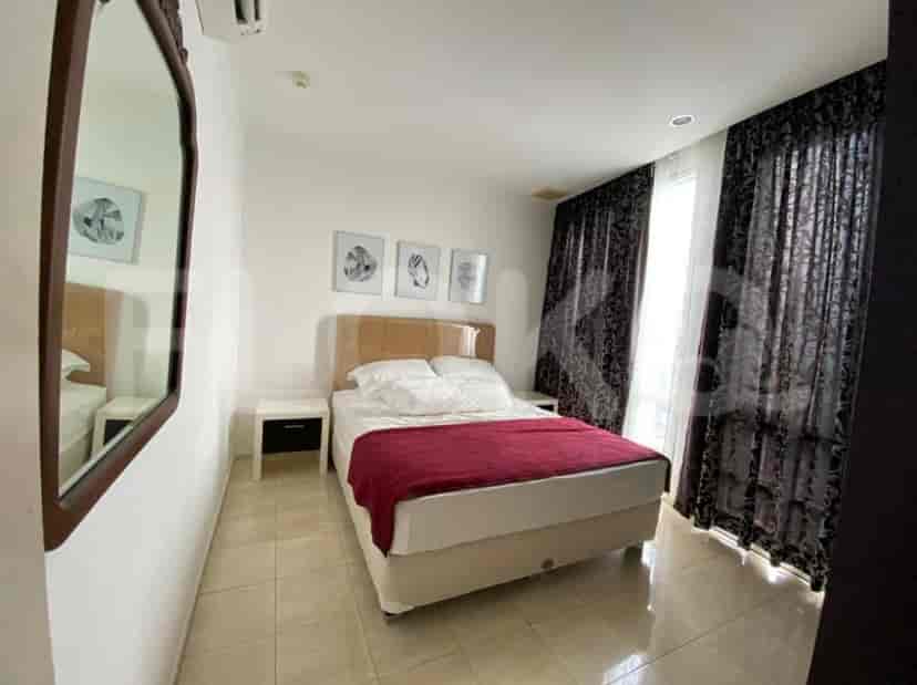 Kamar tidur yang nyaman dengan tempat tidur, cermin, dan gorden.