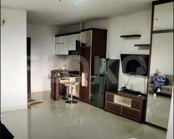 Open-plan living room and kitchen with modern appliances and a small bar.