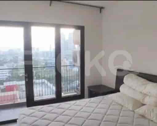Bright bedroom with a queen-sized bed and access to a balcony with city views.