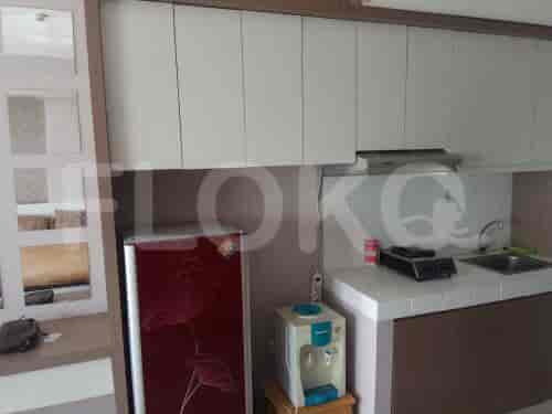 Pengaturan dapur kecil ringkas dengan lemari es merah dan lemari putih.