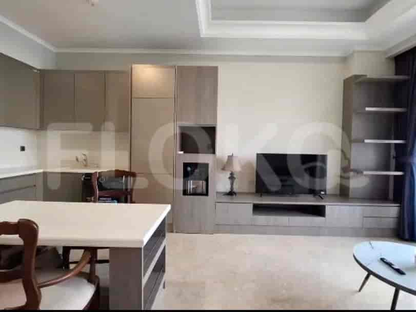 A combined living and dining area with a kitchen, dining table, sofa, and TV.