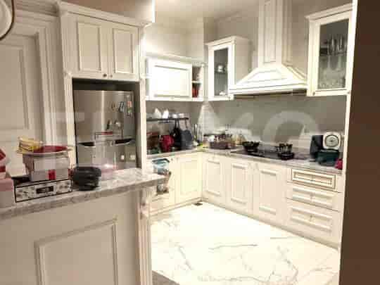 A modern white kitchen with ample cabinet space, a refrigerator, and a stovetop.