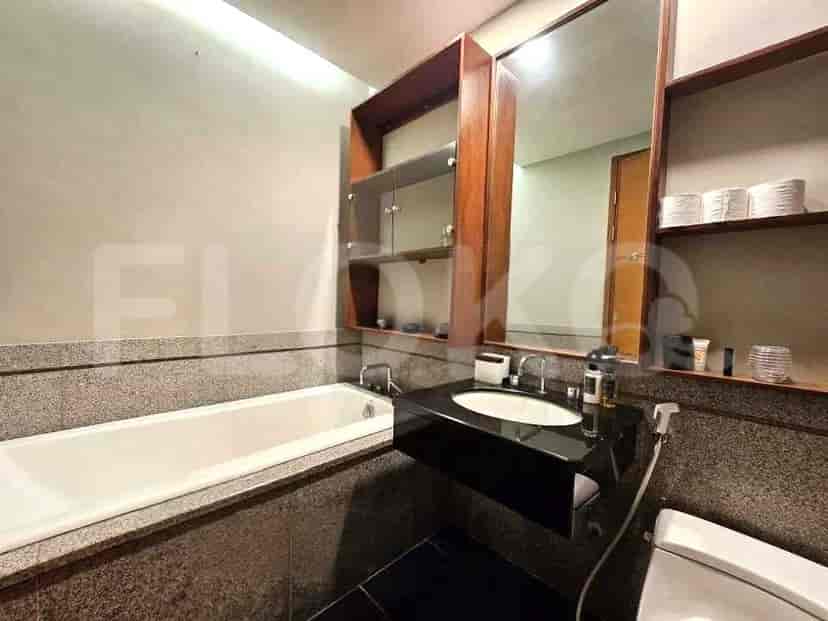 A bathroom with a bathtub, a vanity with a sink, and a large mirror.