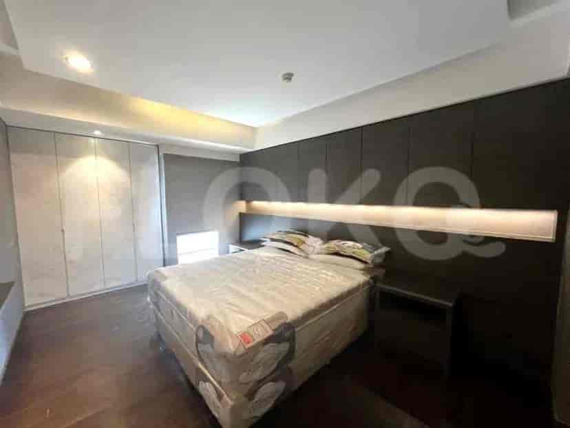 Sebuah kamar tidur dengan tempat tidur, nakas, dan lemari pakaian besar.