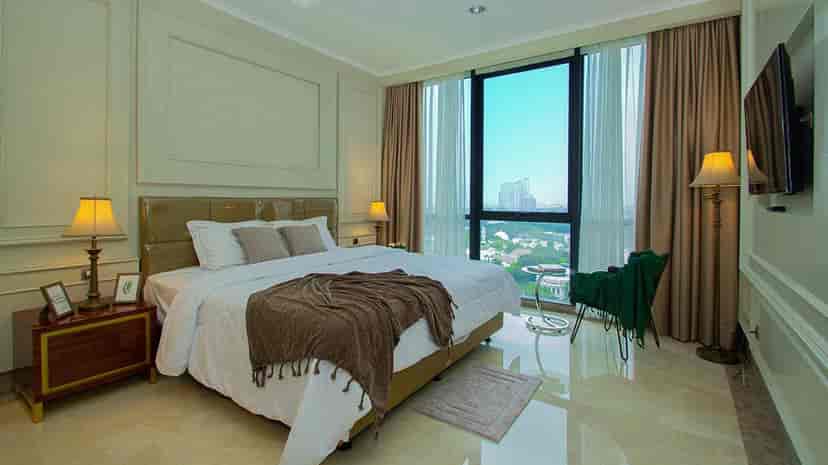 A bedroom with a large window, bed, and city view.