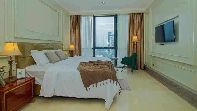 A bedroom with a king-sized bed and a view.