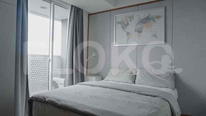 A modern bedroom with a double bed, map artwork, and balcony access.