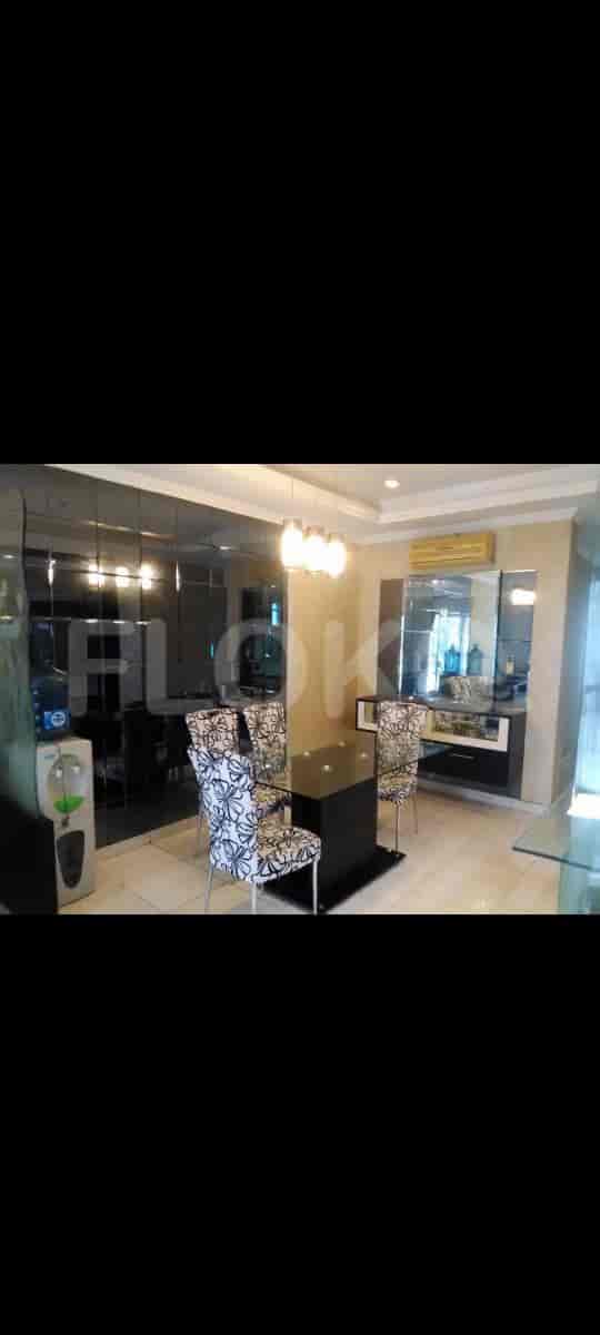 A modern dining area featuring a black square table, chairs, and a mirrored wall.