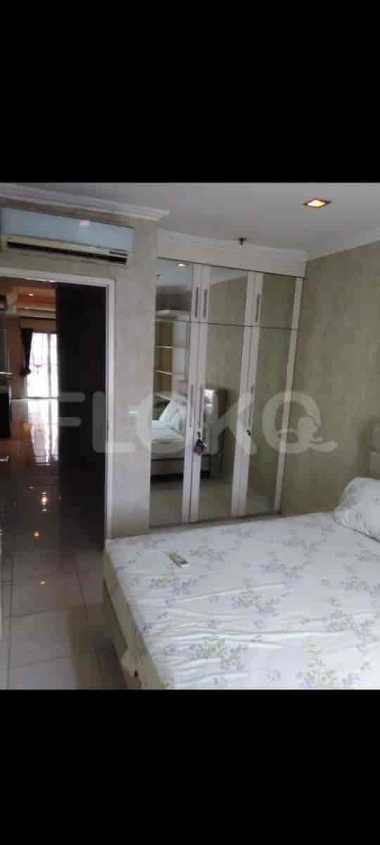 A bedroom with a bed, wardrobe, and an air conditioner.