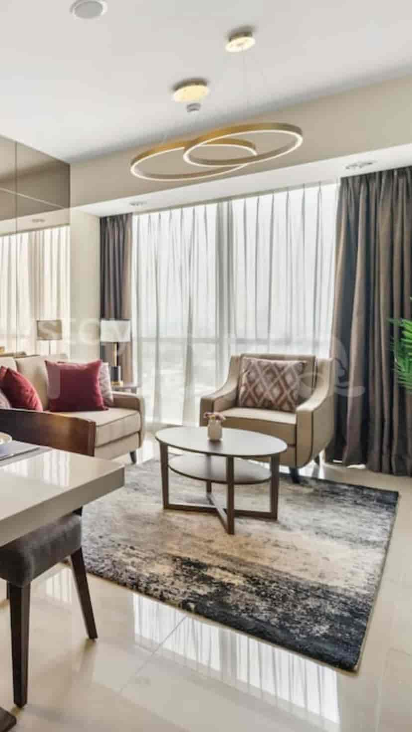 A well-lit living room with a sofa, rug, and a round coffee table.