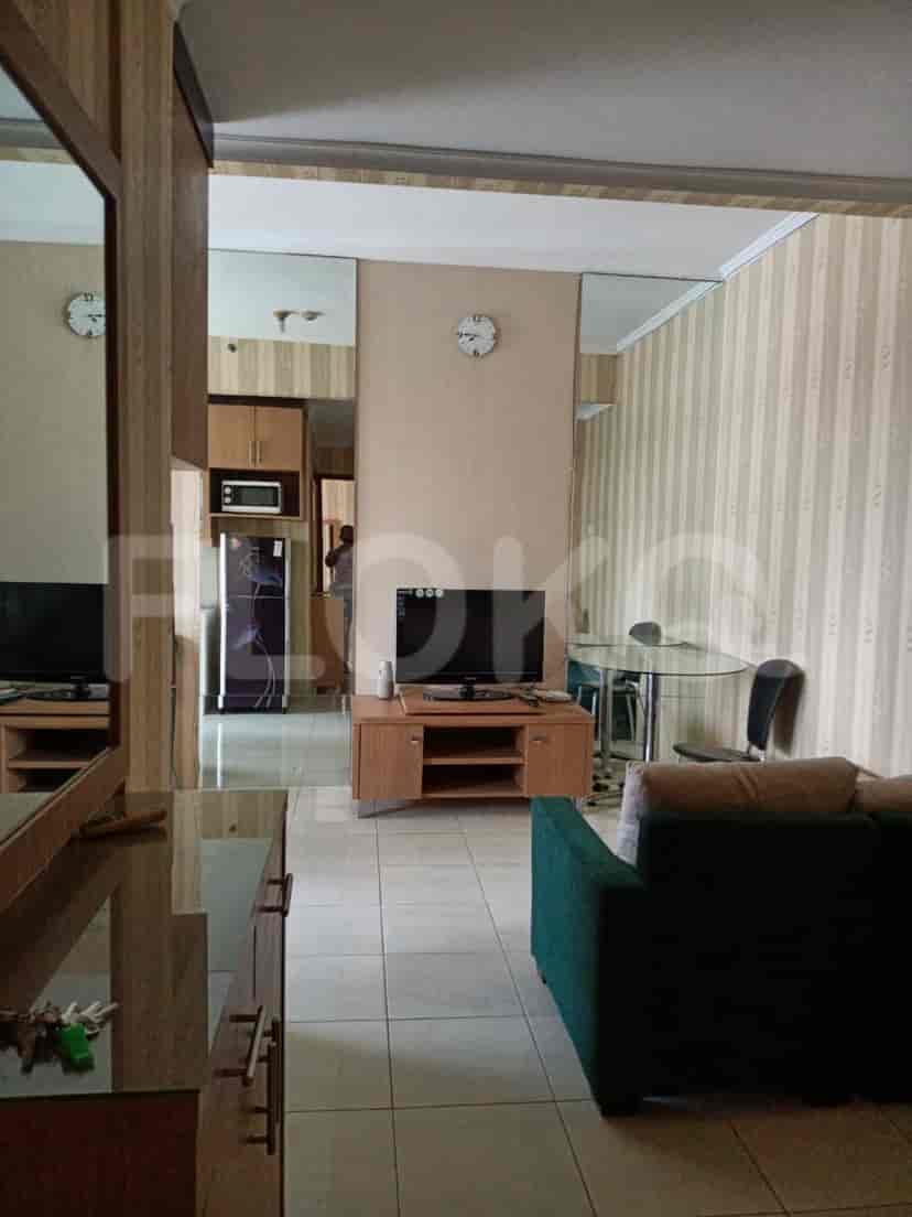 A living room with a smart TV and a view into the kitchen.
