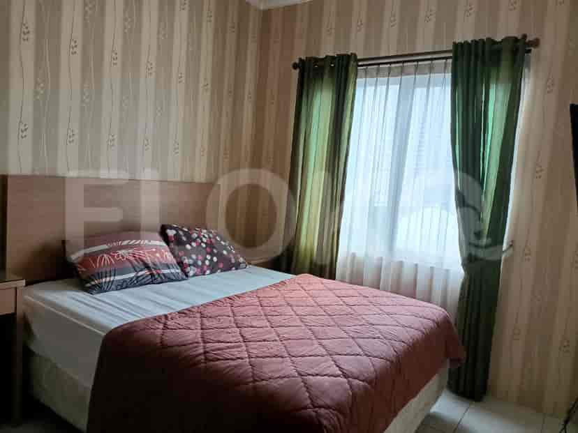 A bedroom with a queen bed, wardrobe, and window.