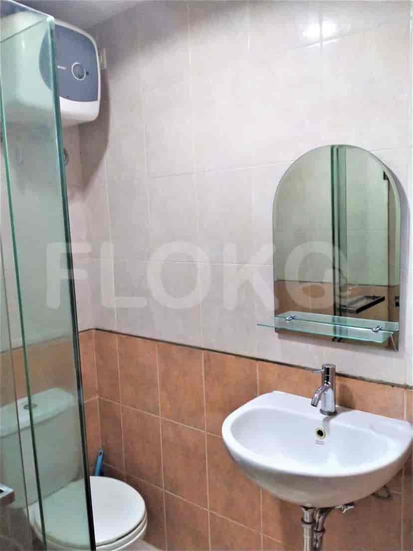 A small bathroom with a sink, mirror, and shower.
