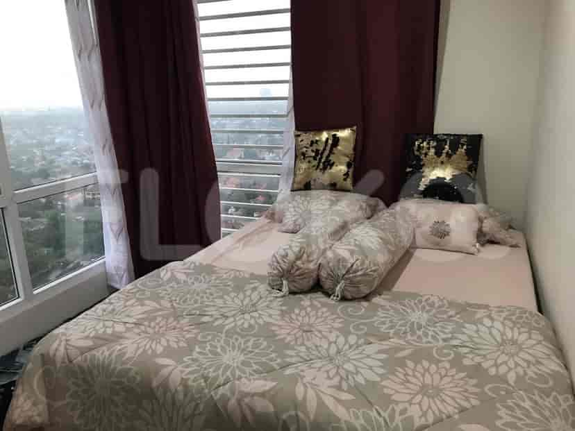 A bedroom with a bed, decorative pillows, and red curtains.