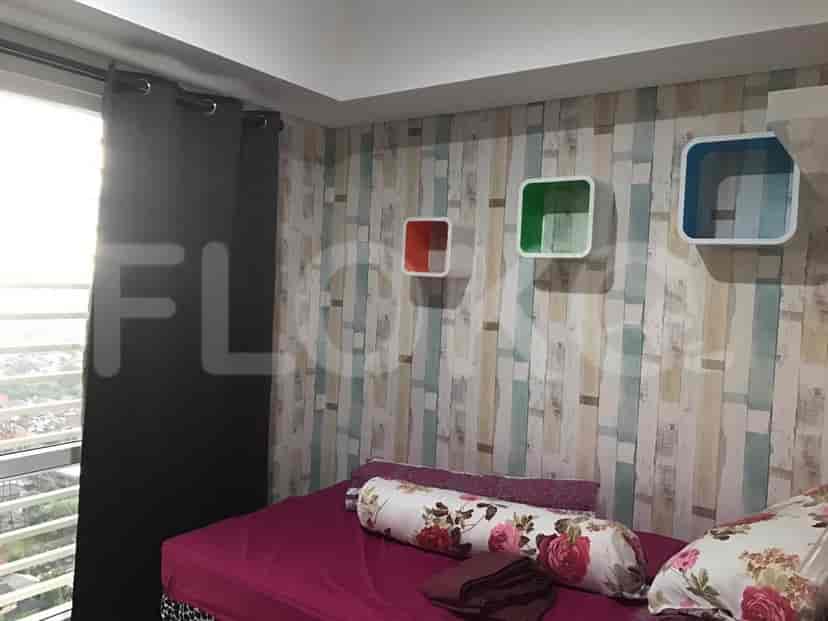 A bedroom with a bed, window with curtains, and decorative wall shelves.