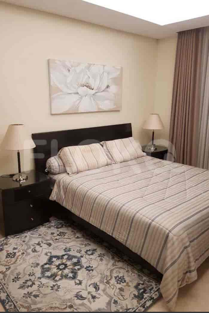 A bedroom with a double bed, two bedside tables with lamps, and a rug.