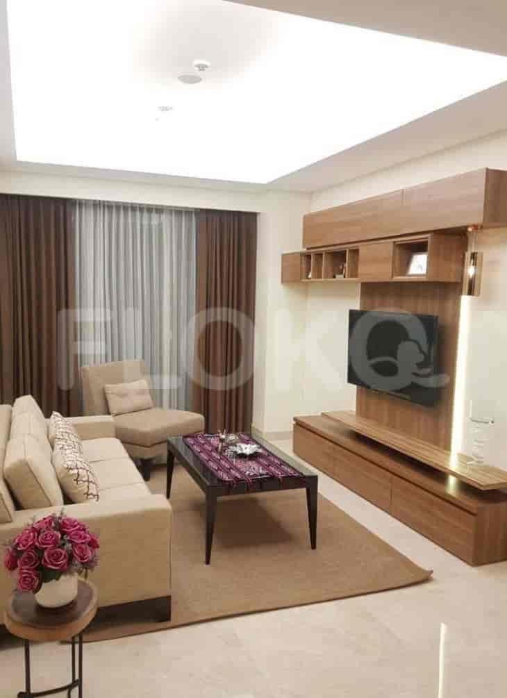 Living room with a sofa, wall-mounted TV, and window.