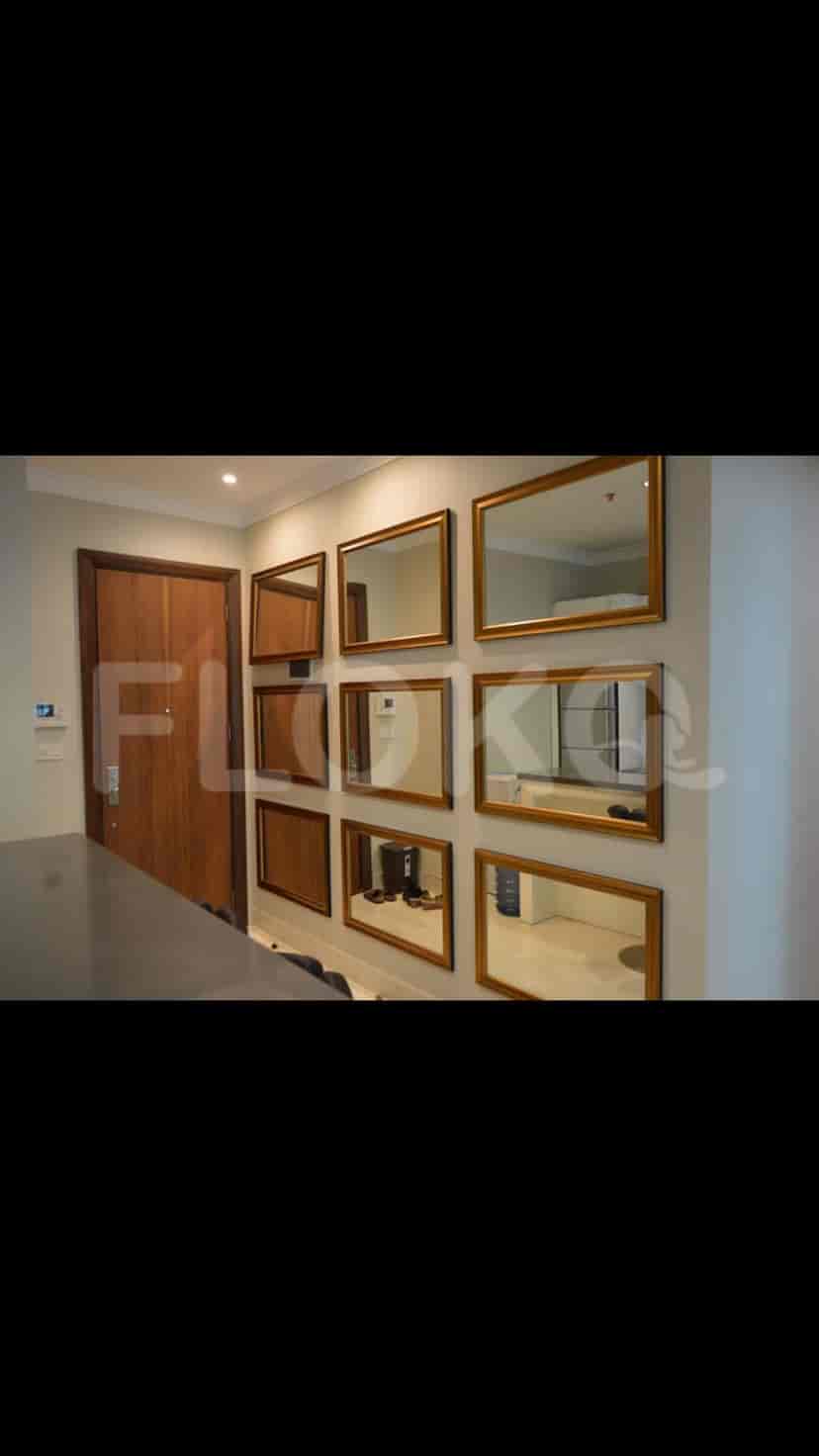 Entrance hall with a wall of mirrors, wooden door, and a hint of the kitchen counter.