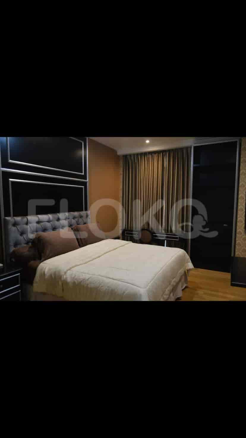Luxurious bedroom with a large bed and dark wood accents.