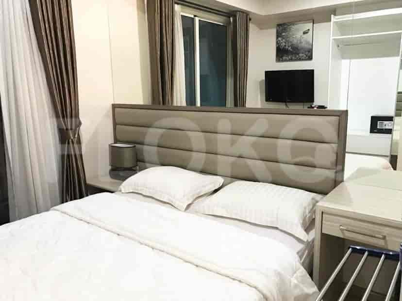 A cozy bedroom featuring a large bed, a television, and a wardrobe for storage.